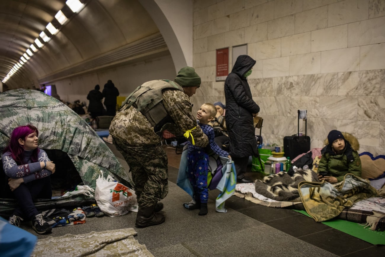 A Ukrainian soldier visits his son who is taking shelter in the lower level of a Kyiv metro station during Russian artillery strikes in Kyiv, Ukraine, on Wednesday, March 2, 2022. Russia said it would press forward with its invasion of Ukraine until its goals are met, as troops were seen moving in a large convoy toward the capital, Kyiv. Photographer: Erin Trieb/Bloomberg via Getty Images