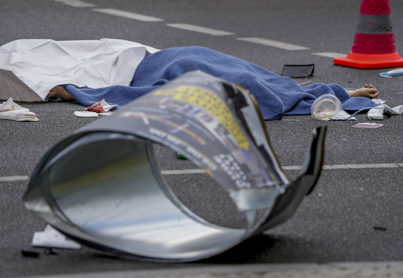 Berlin, 2022. június 8.
Az áldozat letakart holtteste a berlini Breitscheid tér közelében elkövetett gázolás helyszínén 2022. június 8-án. Sajtóhírek szerint egy ember életét vesztette és nyolcan megsebesültek, miután egy kisautó a gyalogosok közé hajtott. A hatóságok még vizsgálják, hogy baleset történt, vagy szándékos gázolás.
MTI/AP/Michael Sohn