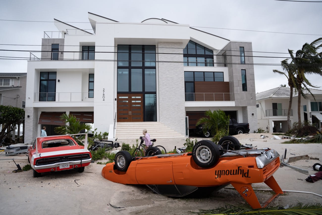 BONITA SPRINGS, FL - SEPTEMBER 29: Muscle cars sit in front of a home after Hurricane Ian on September 29, 2022 in Bonita Springs, Florida. Hurricane Ian brought high winds, storm surges and rain to the area causing severe damage. (Photo by Sean Rayford/Getty Images)